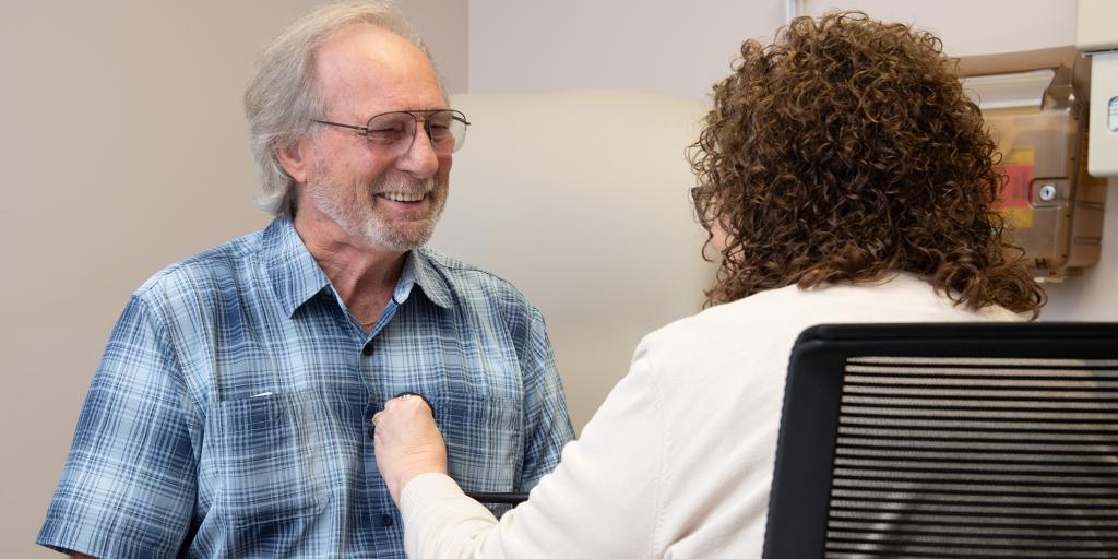 A doctor checking a man's heart with a stethoscope.
