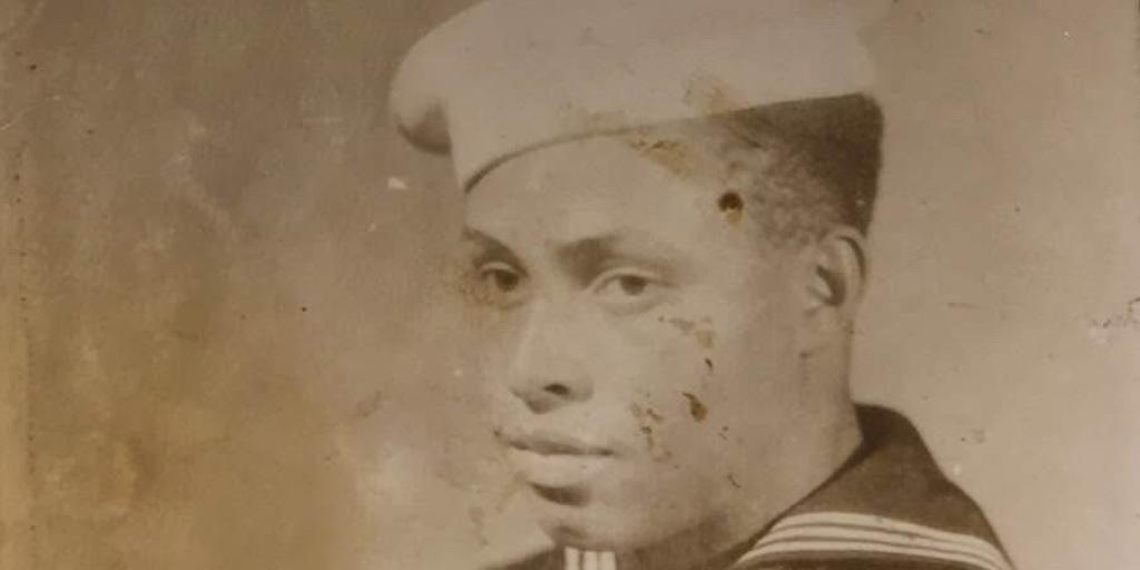 Sepia-toned photo of a sailor with a cap and striped collar.