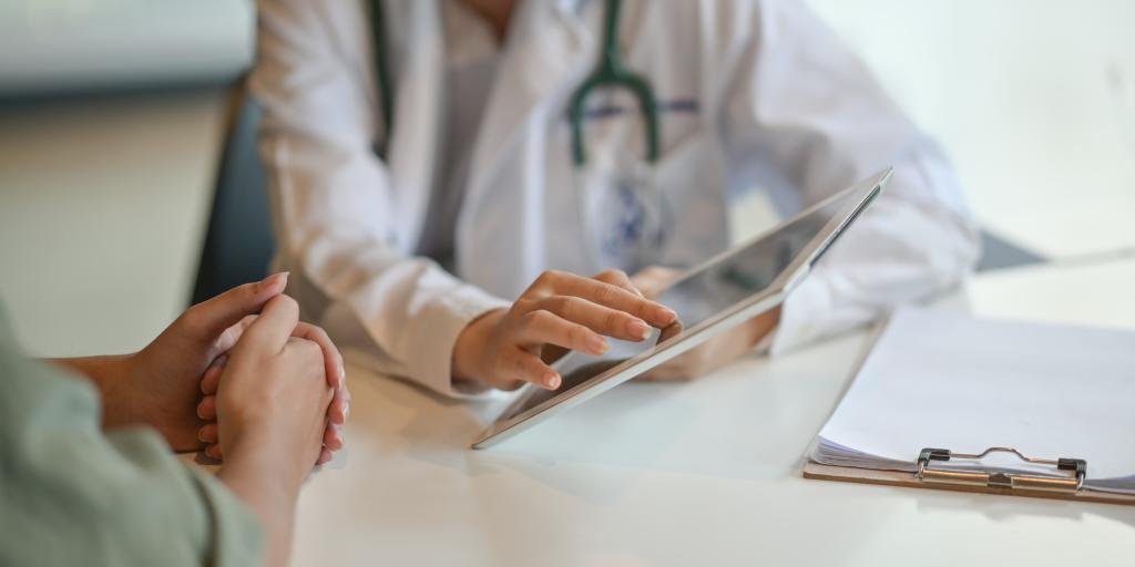 Shot of a doctor showing a patient some information on a digital tablet