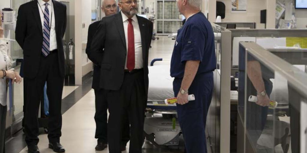 Group of formally dressed men in a hospital hallway.