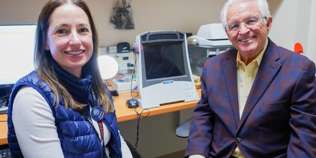 A veteran and a VA audiologist smile after a VA hearing appointment.