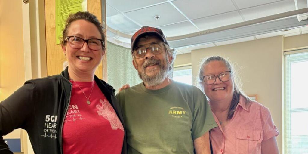 Three people smiling, standing in doorway