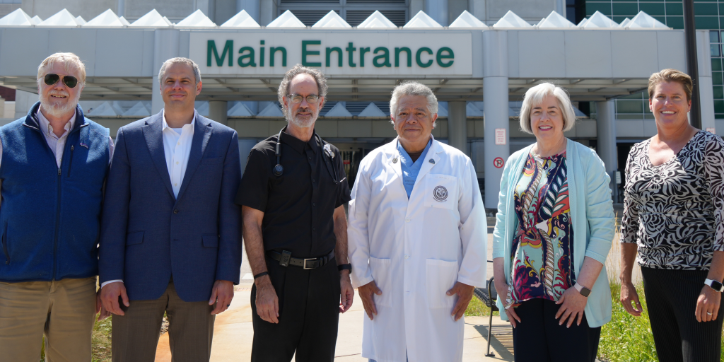 Six people stand in front of a building labeled "Main Entrance."