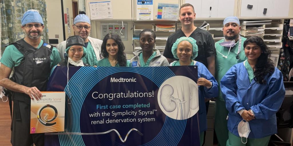 Group of medical professionals in scrubs holding a sign that says "Congratulations!"