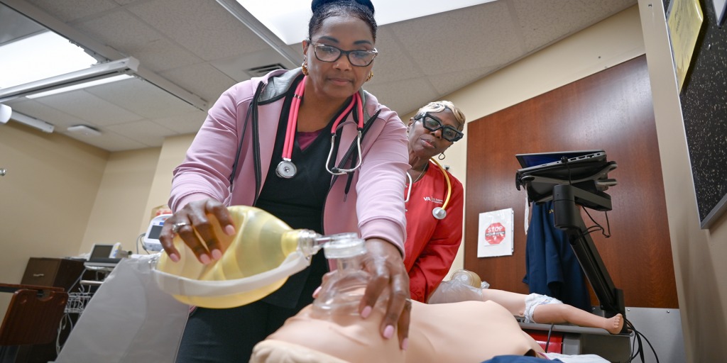 Ann Woods (left) conducts her quarterly Resuscitation Quality Improvement training as Theresa Turner (right) observes the exercise.