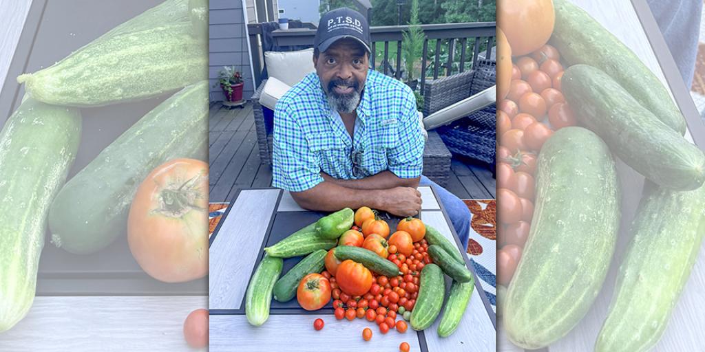 Edward Beale, smiling, surrounded by vegetables.