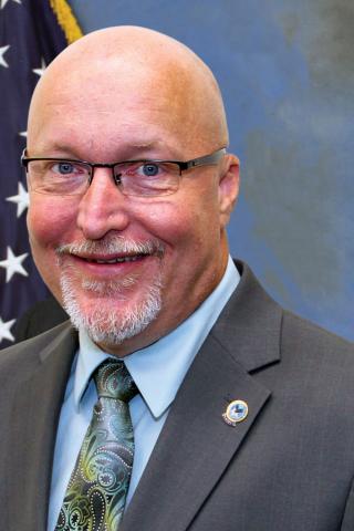 bald caucasian man wearing glasses.