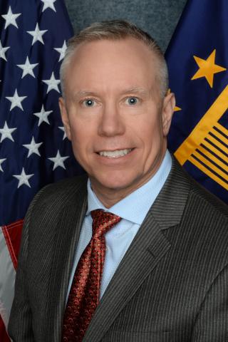 Portrait of Executive Director James McLain, US and VA flags in background