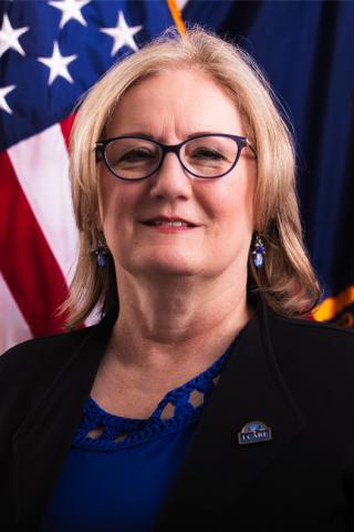 Jeanette Hester, Acting Deputy Director standing with the US flag