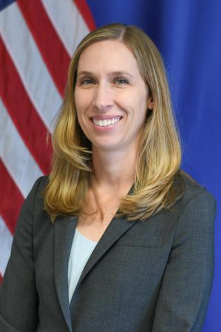 smiling professional female with an American flag in the background