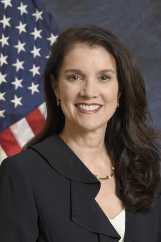 head and shoulder photograph with flag behind woman