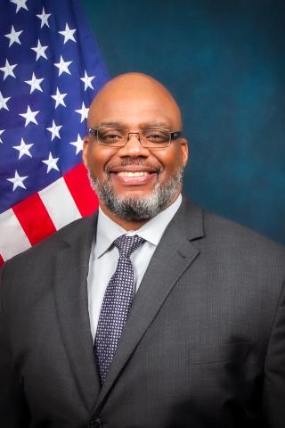 Robert Sellers sitting in front of U.S. flag