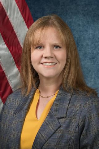 Bailey Wells sits in front of the American flag.