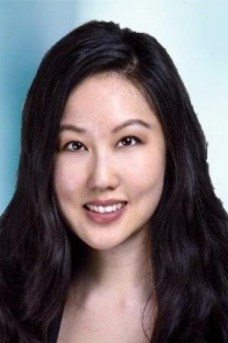 Portrait of a woman with long black hair smiling.