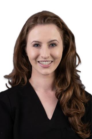 Headshot of a smiling woman with long brown hair and wearing a black top.