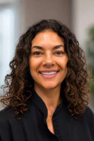 Headshot of a woman with curly hair smiling.
