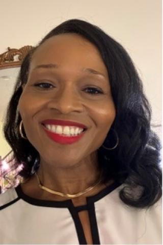 Portrait of a woman with black hair, red lipstick, and a white shirt smiling.
