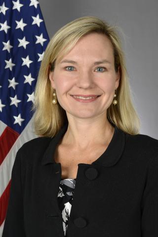 woman smiling in front of flag