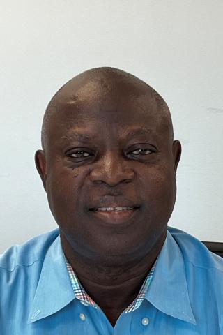 Photo of a bald man in a blue shirt smiling at the camera.