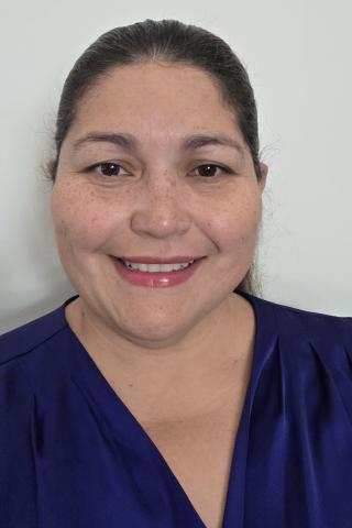 Woman in blue blouse smiling at the camera.