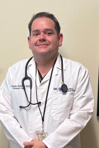 Smiling doctor in white coat with stethoscope around his neck.