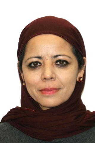 Portrait of a woman wearing a gray shirt and red hijab.