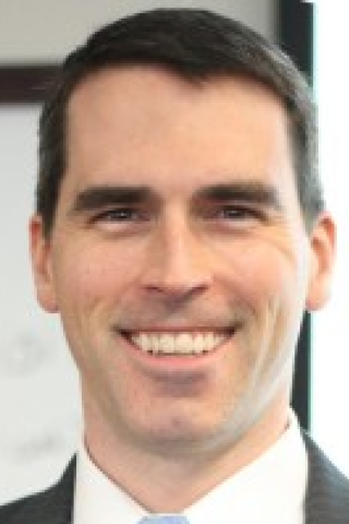 Portrait of a smiling man in a suit and tie.
