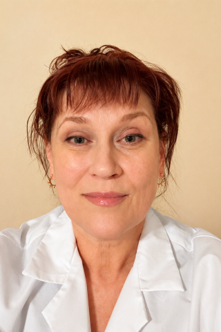 Woman with short brown hair wearing a white lab coat.
