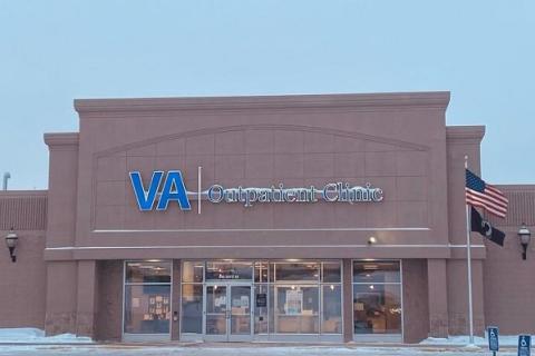 photo of a beige building that has a sign saying VA Outpatient Clinic