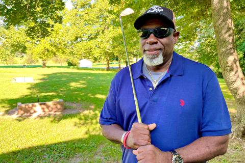 Photo of Paul White with a golf club.