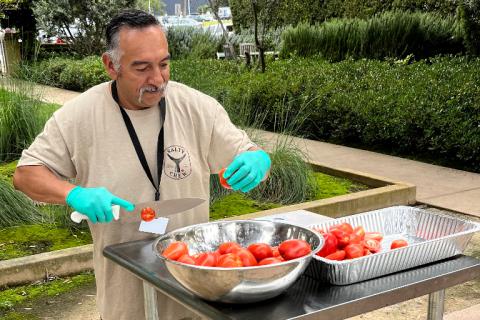 Man slicing tomatoes.