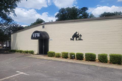 Tan building with kneeling soldier and VFW at the entryway