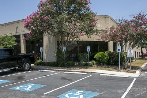 Corner view of a medical plaza with a large crape myrtle with pink blooms in front