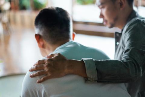 Man with hand on back of another man
