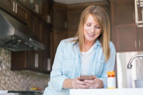 Woman looking at phone in kitchen