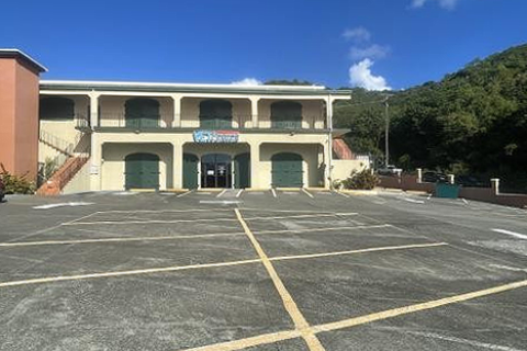 A yellow-painted two-story building with the Vet Center sign displayed on the balcony above the entrance located on the main floor.