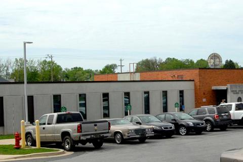 One story building with a white façade. Parking in front 