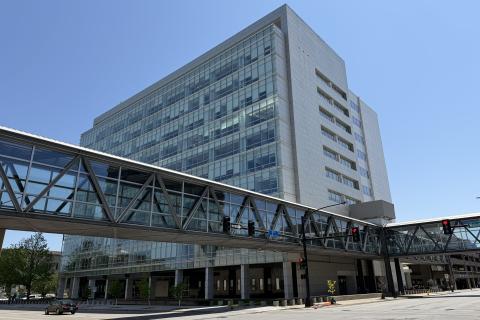 Glass and concrete building with suspended skywalk access running to the second floor.