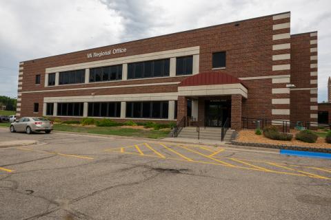 Two story brick building with windows and covered entrance. 