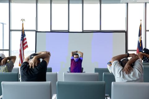 Whole Health staff stretching with Veterans during a chair yoga presentation during the Whole Health Summit at Corpus Christi West Point VA Clinic.