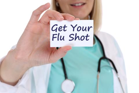 Female provider holding a "get your flu shot" message