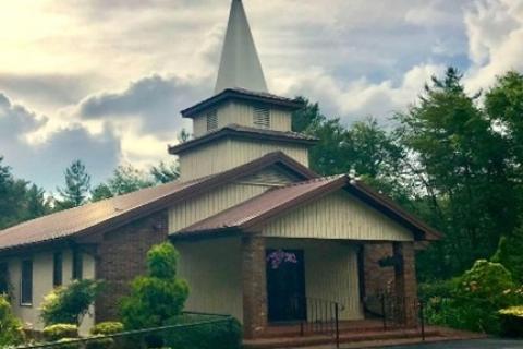 Brick and tan structure with chapel and cross adorning the building  