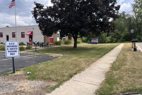 White building with red doors and awnings.