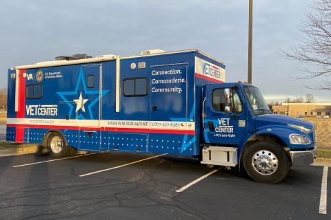 Large blue Recreational Vehicle. Red and White stripes. White text with Vet Center logo.