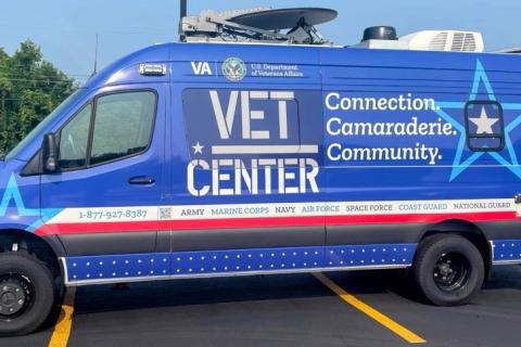 Mercedes Sprinter van. Blue vehicle wrap with red and white stripes. Vet Center logo and slogan.