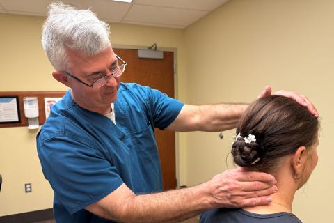 Dr. Paul Bickford performs a preliminary exam of a Veterans neck as part of their chiropractic care at the Abilene VA CBOC.