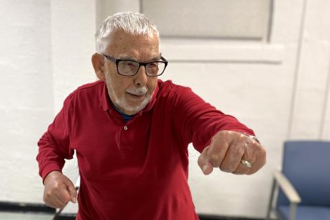 100-year-old Veteran performs a standing Tai Chi move. 