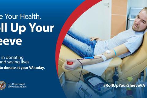 Caucasian man in jeans and t-shirt, with blond hair, reclined in a tan chair holding a red ball, donating blood.