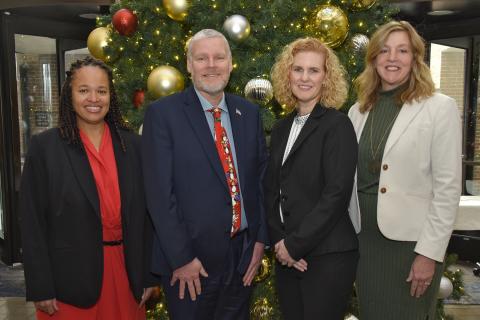 The Dayton VA Medical Center Executive Leadership Team dressed professional and standing in front of a holiday tree.