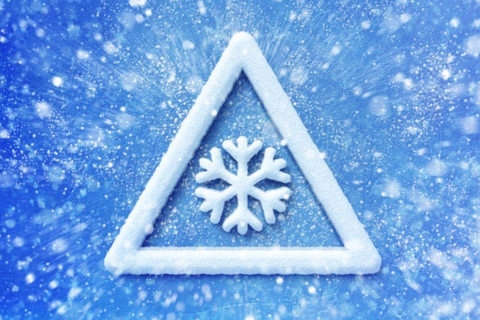 White triangle with a snowflake in the center on a blue background.